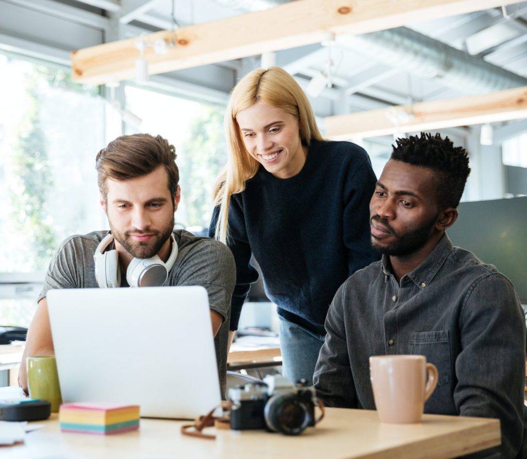 a group of people looking at a laptop
