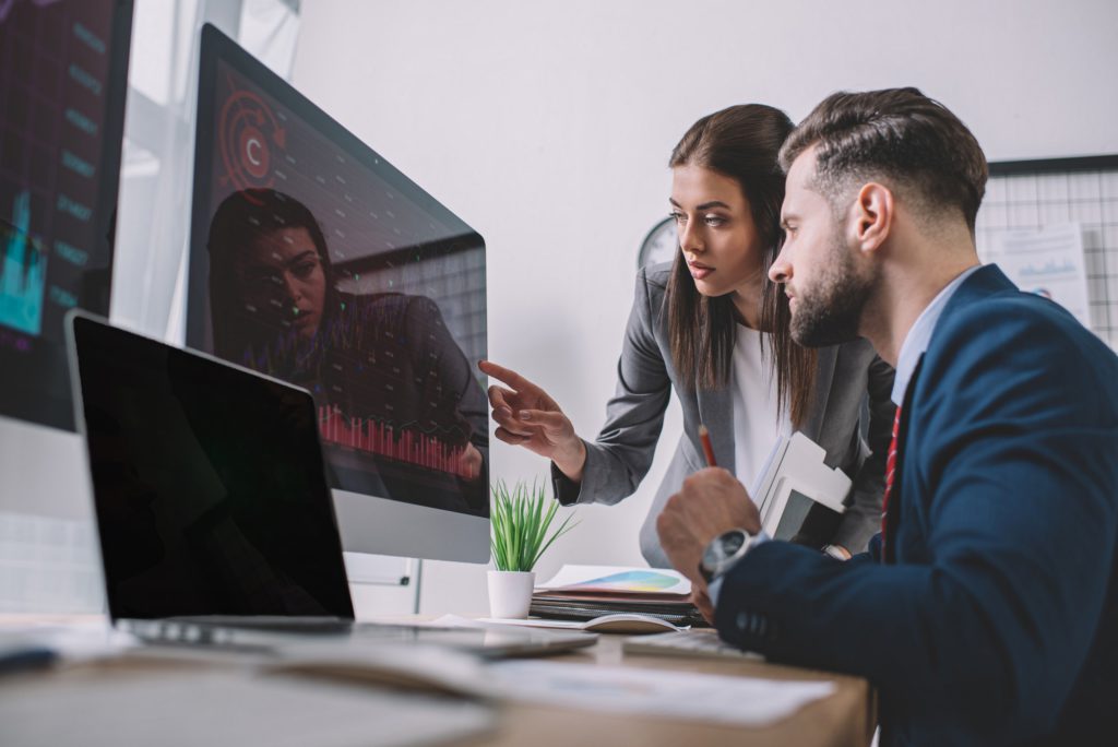 a man and woman looking at a computer screen
