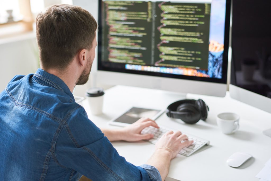 a man sitting at a desk using a computer